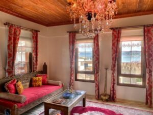 El oymalı masif ahşap sedir, kristal avize ve klasik etnik dekorasyon detaylarıyla tasarlanmış lüks butik otel oturma alanı interior görünümü
