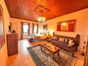 El oymalı masif ahşap sedir, klasik dekorasyon detayları ve otantik atmosferle tasarlanmış lüks butik otel süit odası interior görünümü