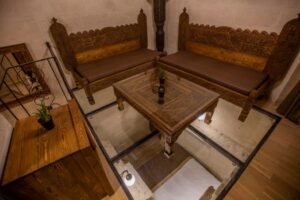 El oymalı masif ahşap sedir takımı ve etnik orta sehpa ile tasarlanmış otantik butik otel oturma alanı