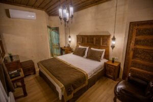 El oymalı masif ahşap yatak başlığı ve etnik gardırop detaylarıyla dekore edilmiş otantik butik otel odası interior tasarımı