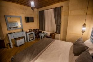 Masif ahşap detaylar ve etnik dekorasyonla tasarlanmış sıcak atmosferli butik otel odası iç mekan görünümü